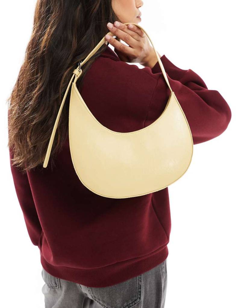 ASOS DESIGN - Halbmondförmige Schultertasche in Buttermilch mit asymmetrischem Design und Schnalle-Gelb von ASOS DESIGN