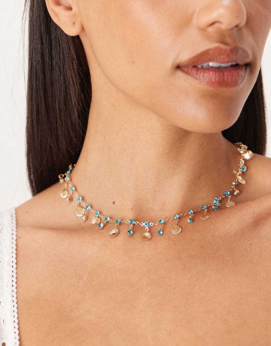 ASOS DESIGN - Halskette mit kleinen goldfarbenen Muscheln und Kunstkristallanhängern in Blau von ASOS DESIGN