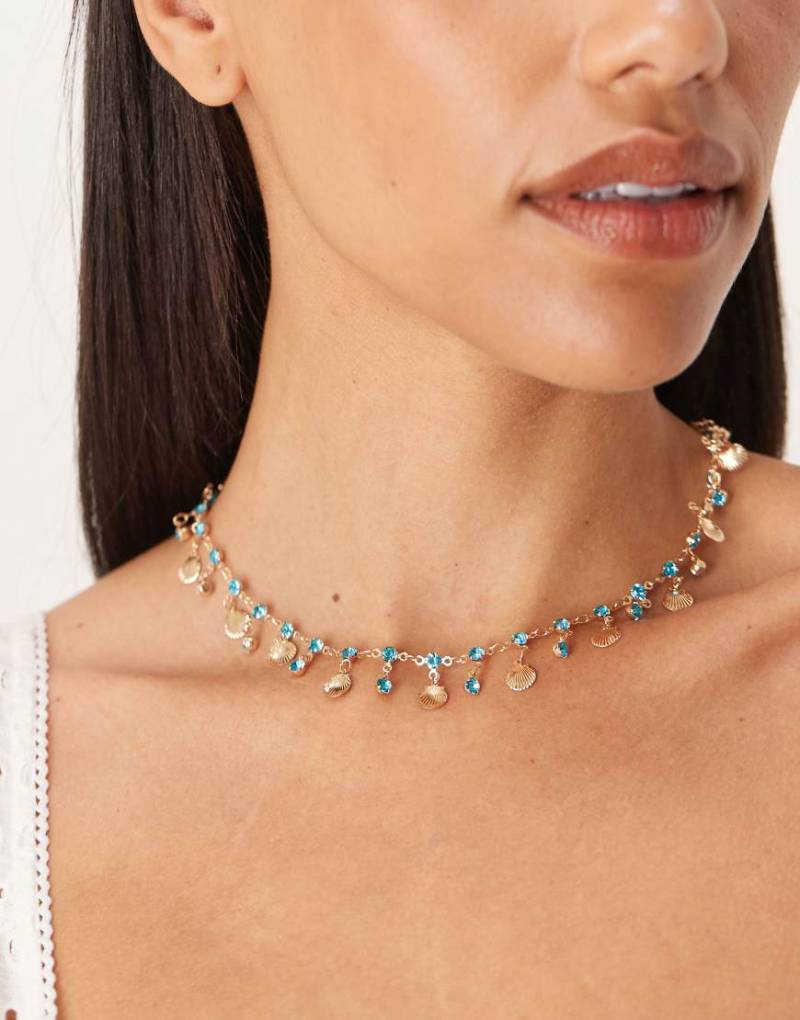 ASOS DESIGN - Halskette mit kleinen goldfarbenen Muscheln und Kunstkristallanhängern in Blau von ASOS DESIGN