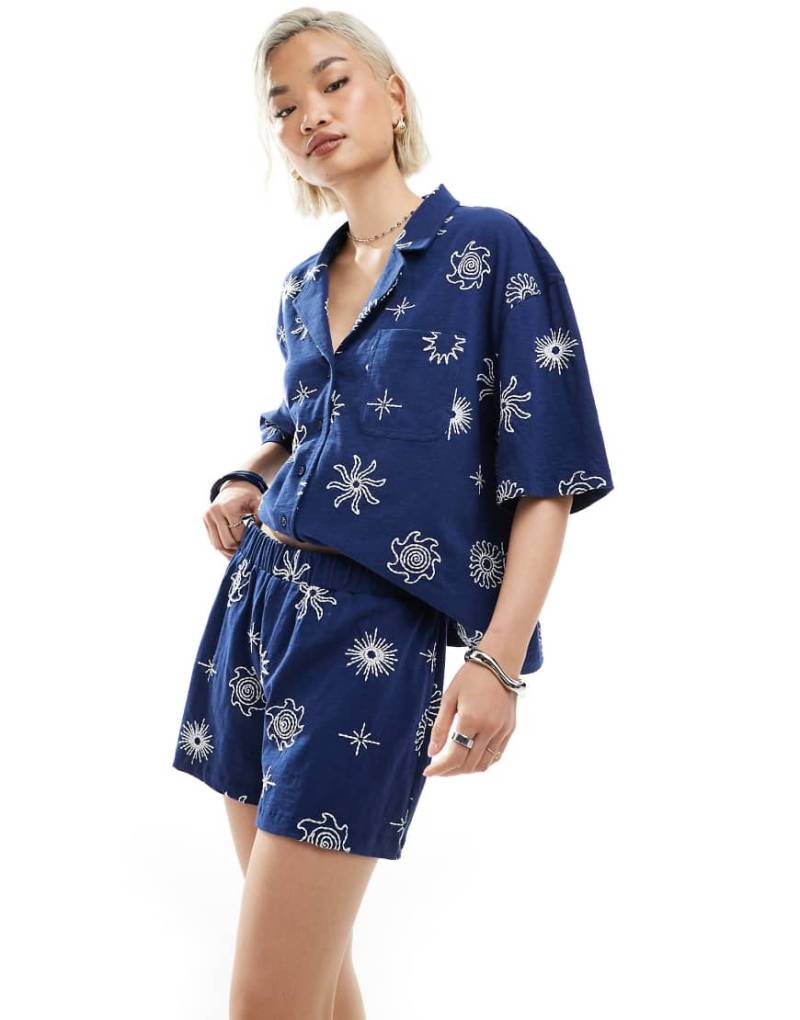 ASOS DESIGN - Hemd in Marineblau mit Reverskragen und Sonnenwende-Stickereien, Kombiteil ASOS DESIGN - Hemd in Marineblau mit Reverskragen und Sonnenwende-Stickereien, Kombiteil von ASOS DESIGN