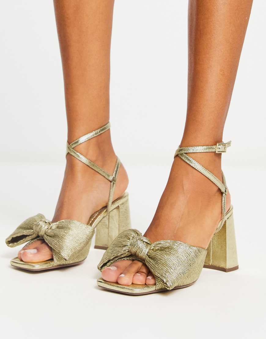ASOS DESIGN - Hitched - Sandalen in Goldoptik mit Schleifendetail und mittelhohem Blockabsatz-Goldfarben von ASOS DESIGN