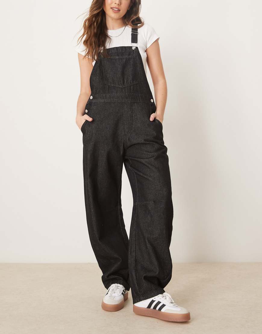 ASOS DESIGN - Jeans-Latzhose in Schwarz mit abgerundetem Beinschnitt von ASOS DESIGN