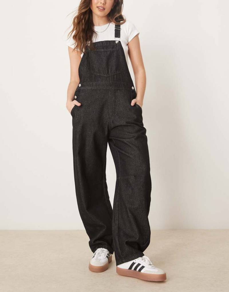 ASOS DESIGN - Jeans-Latzhose in Schwarz mit abgerundetem Beinschnitt von ASOS DESIGN