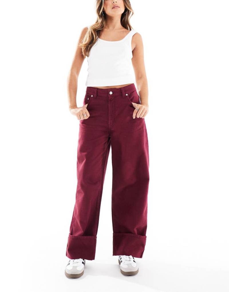 ASOS DESIGN - Jeans in Burgunderrot mit Saumaufschlag von ASOS DESIGN