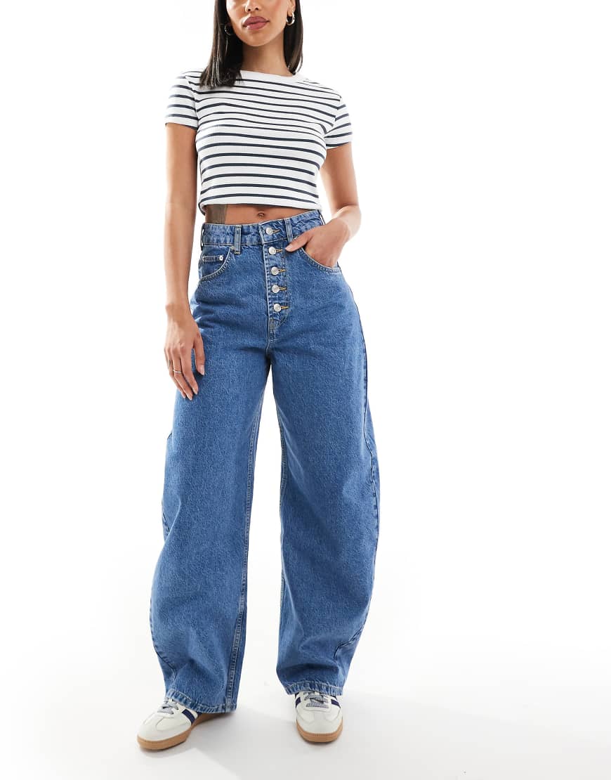 ASOS DESIGN - Jeans in Mittelblau mit Knopfleiste und extrem abgerundetem Beinschnitt von ASOS DESIGN
