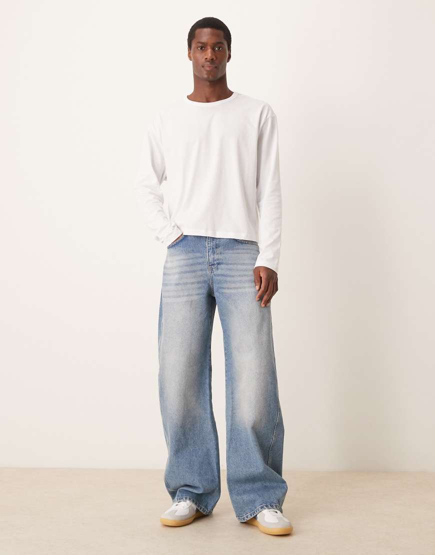 ASOS DESIGN - Superweite Jeans in mittelblauer Waschung mit verdrehten Nähten von ASOS DESIGN