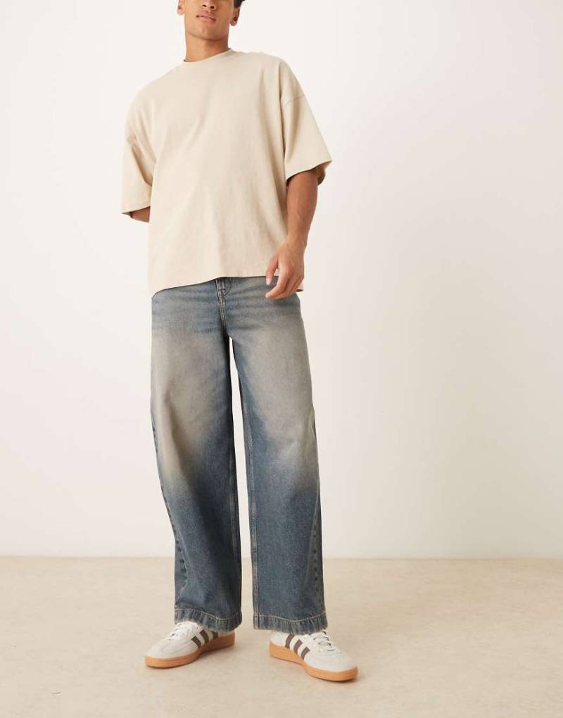 ASOS DESIGN - Jeans in mittelblauer Waschung mit abgerundetem Beinschnitt und Farbstich von ASOS DESIGN