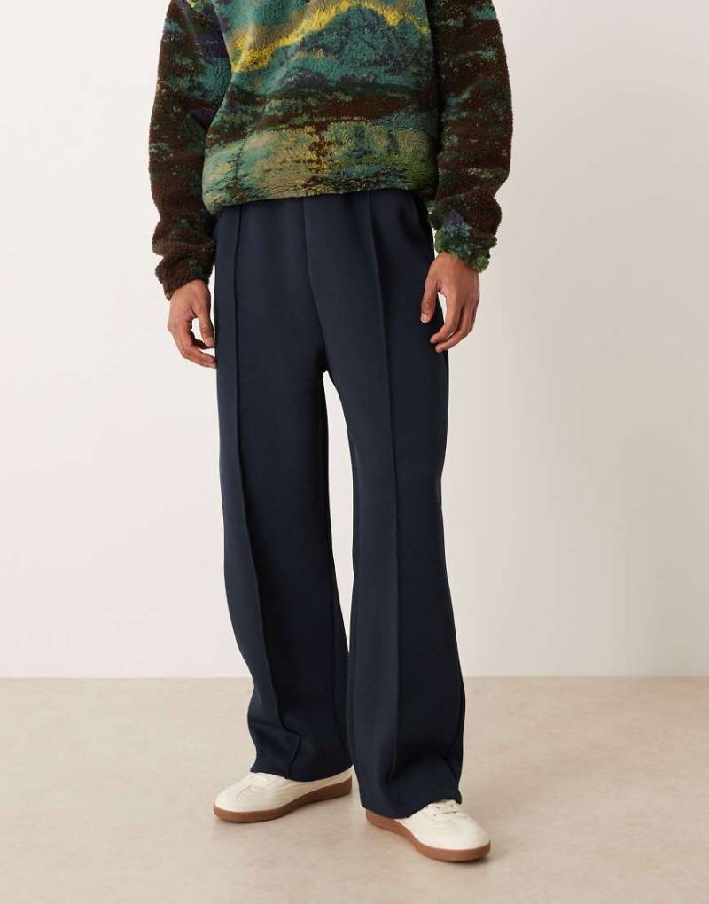 ASOS DESIGN - Jogginghose aus schwerem neoprenartigem Stoff in Marineblau mit weitem Bein und Falten von ASOS DESIGN