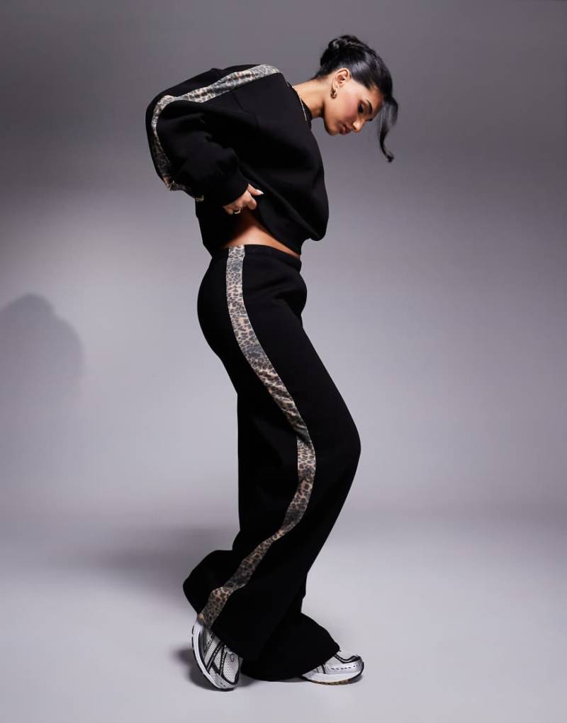ASOS DESIGN - Jogginghose in Schwarz mit weitem Bein und seitlichem Streifen mit Leopardenmuster, Kombiteil-Bunt von ASOS DESIGN