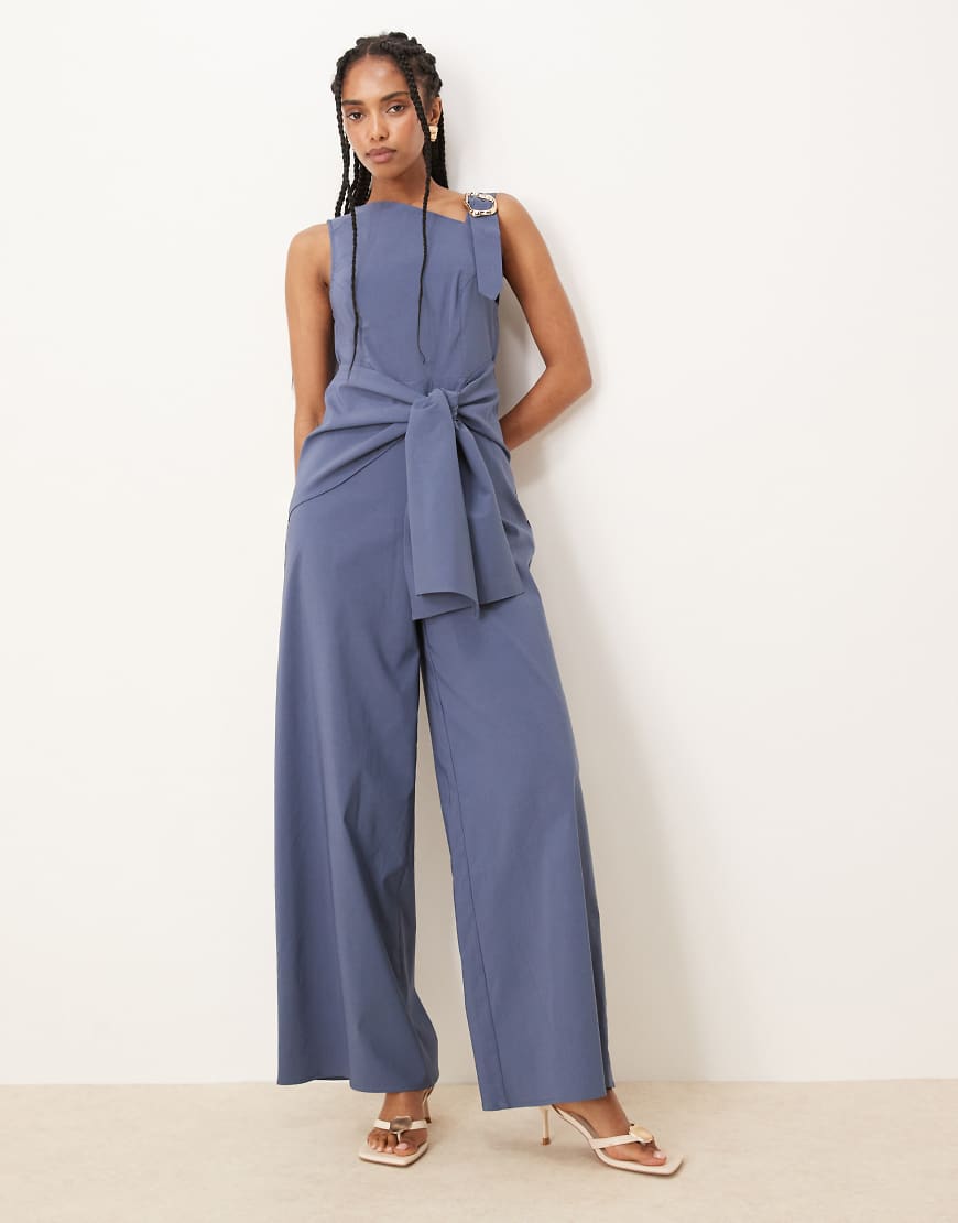ASOS DESIGN - Jumpsuit in Marineblau mit Wickeldesign und asymmetrischer Verzierung am Träger in Flüssiggold-Optik ASOS DESIGN - Jumpsuit in Marineblau mit Wickeldesign und asymmetrischer Verzierung am Träger in Flüssiggold-Optik von ASOS DESIGN