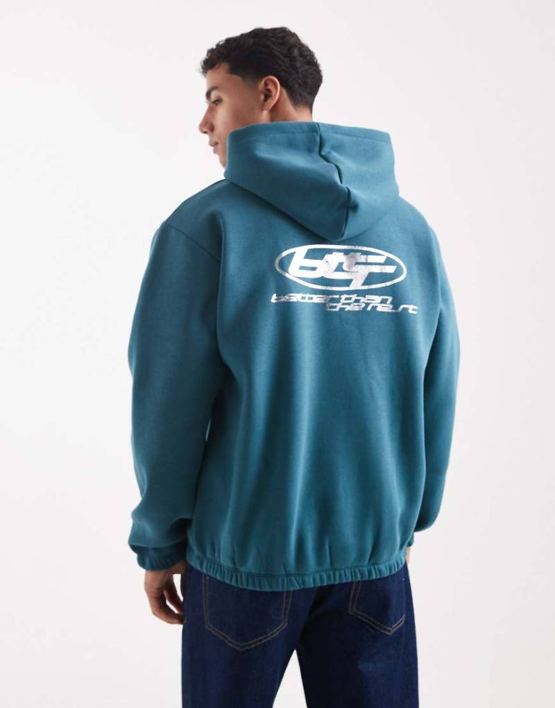 ASOS DESIGN - Kapuzenpullover in Petrolblau mit Metallic-Sportprint-Marineblau von ASOS DESIGN