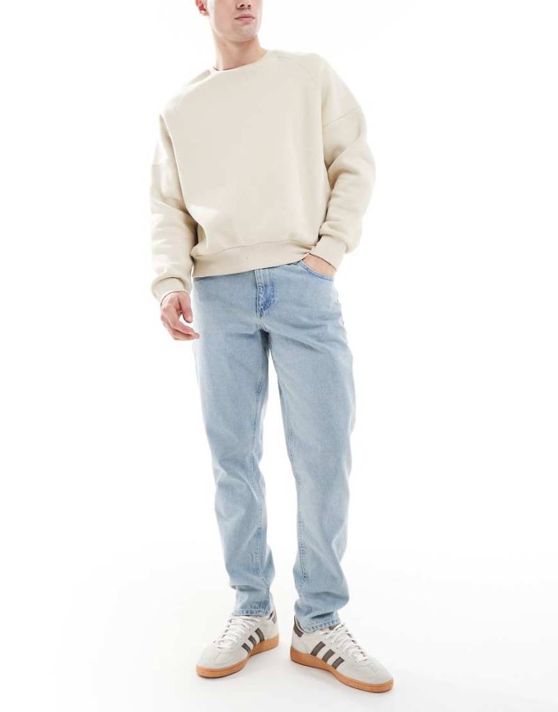 ASOS DESIGN - Karottenjeans in hellblauer Stone-Waschung-Schwarz von ASOS DESIGN