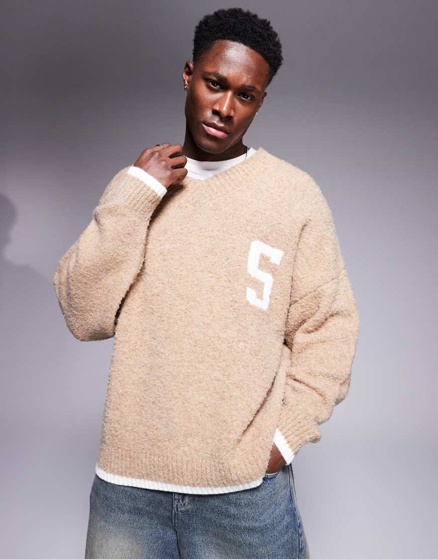 ASOS DESIGN - Kastiger, strukturierter Oversize-Strickpullover in Beige mit V-Ausschnitt, Brustprint und Zierrand-Neutral ASOS DESIGN - Kastiger, strukturierter Oversize-Strickpullover in Beige mit V-Ausschnitt, Brustprint und Zierrand-Neutral von ASOS DESIGN