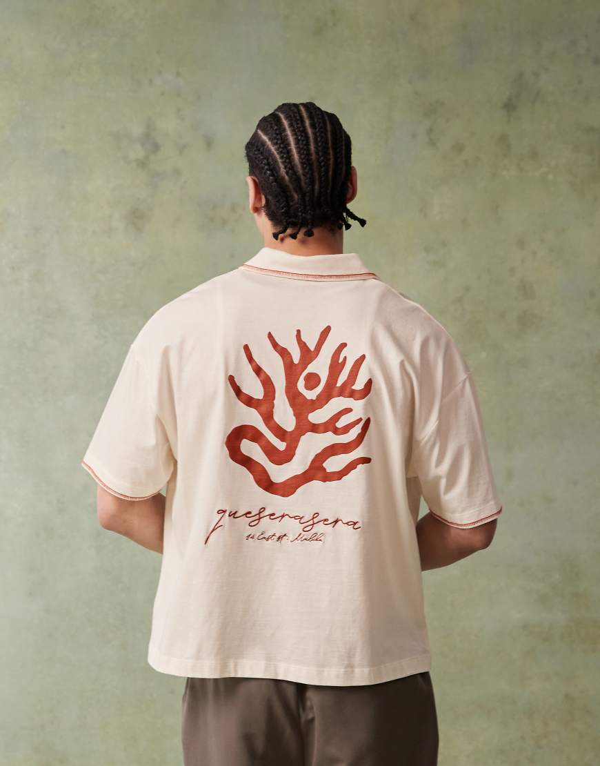 ASOS DESIGN - Kastiges, kurzärmliges Poloshirt in Wollweiß mit Stickerei auf Brusthöhe und Grafikprint am Rücken von ASOS DESIGN