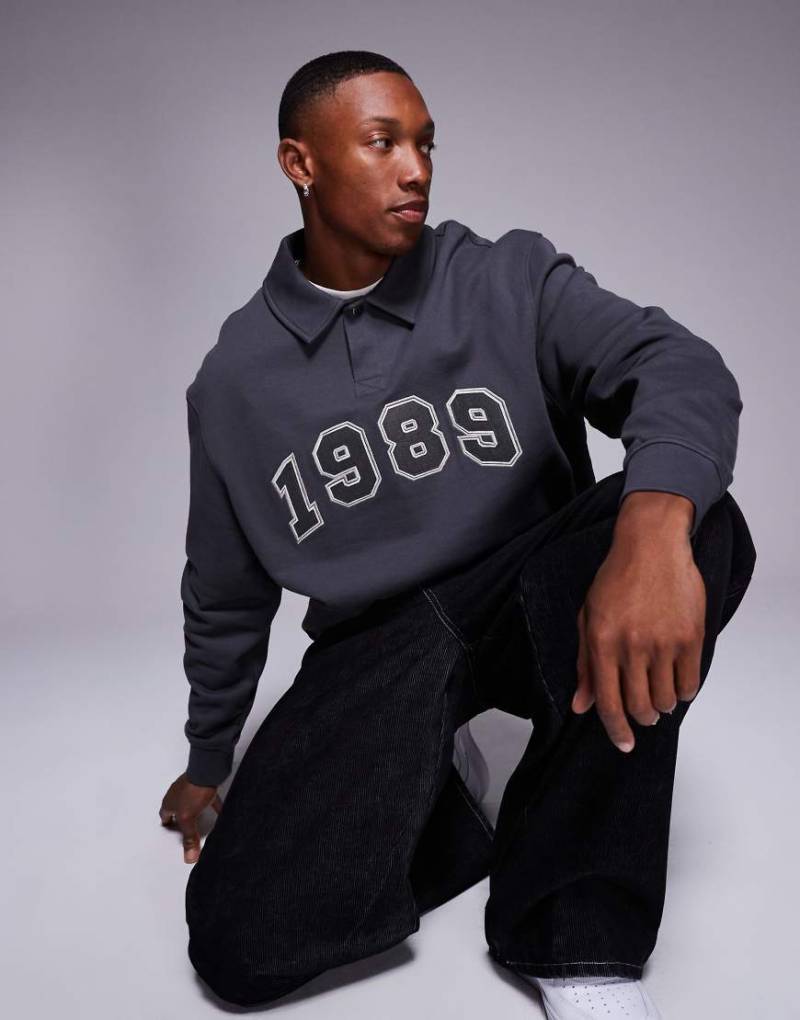 ASOS DESIGN - Kastiges Oversize-Polo-Sweatshirt in Anthrazit mit Applikationsprint-Grau von ASOS DESIGN