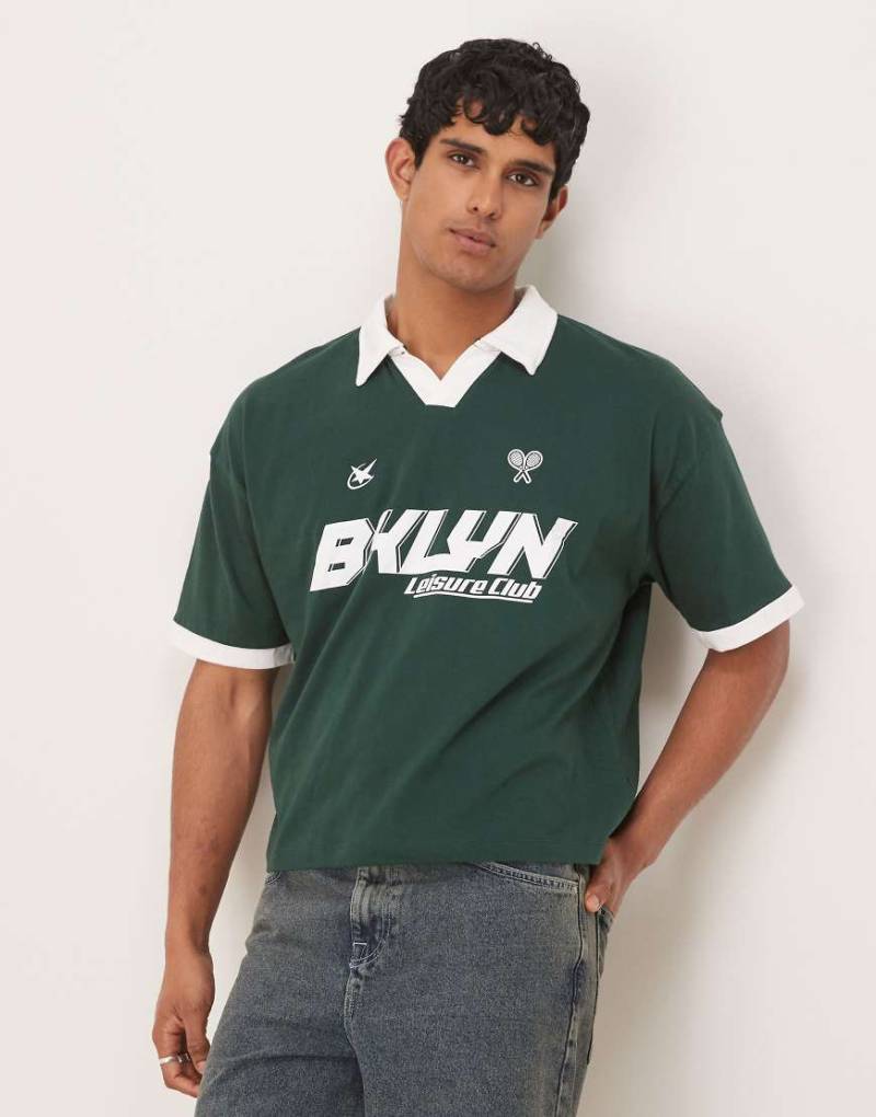 ASOS DESIGN - Kastiges Oversize-Polohemd in Dunkelgrün mit Sport-Prints von ASOS DESIGN