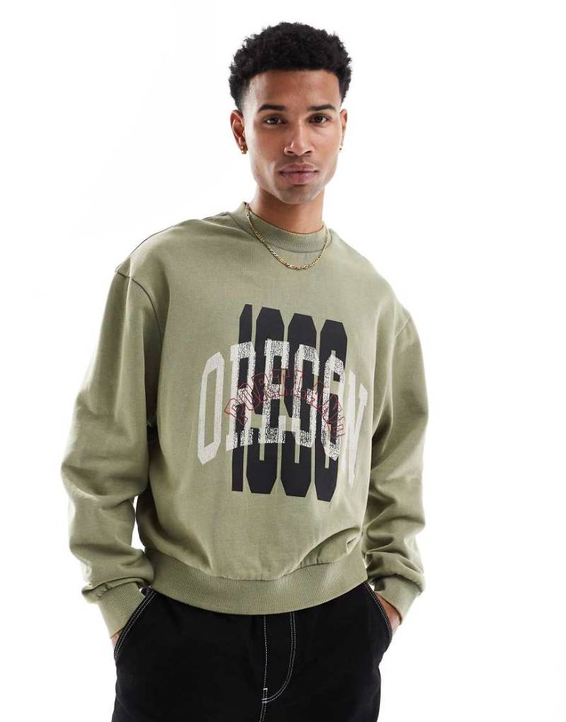 ASOS DESIGN - Kastiges Oversize-Sweatshirt in grüner Acid-Waschung mit Lagenprint von ASOS DESIGN