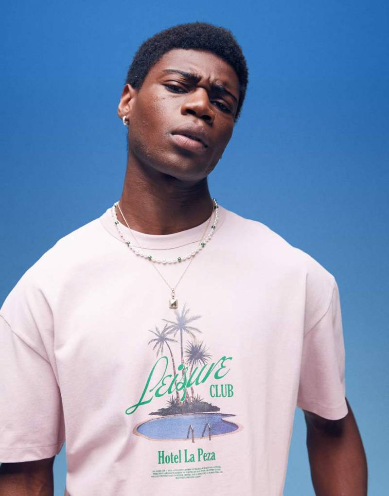 ASOS DESIGN - Schweres, kastiges Oversize-T-Shirt in verwaschenem Rosa mit Palmenprint auf der Brust von ASOS DESIGN