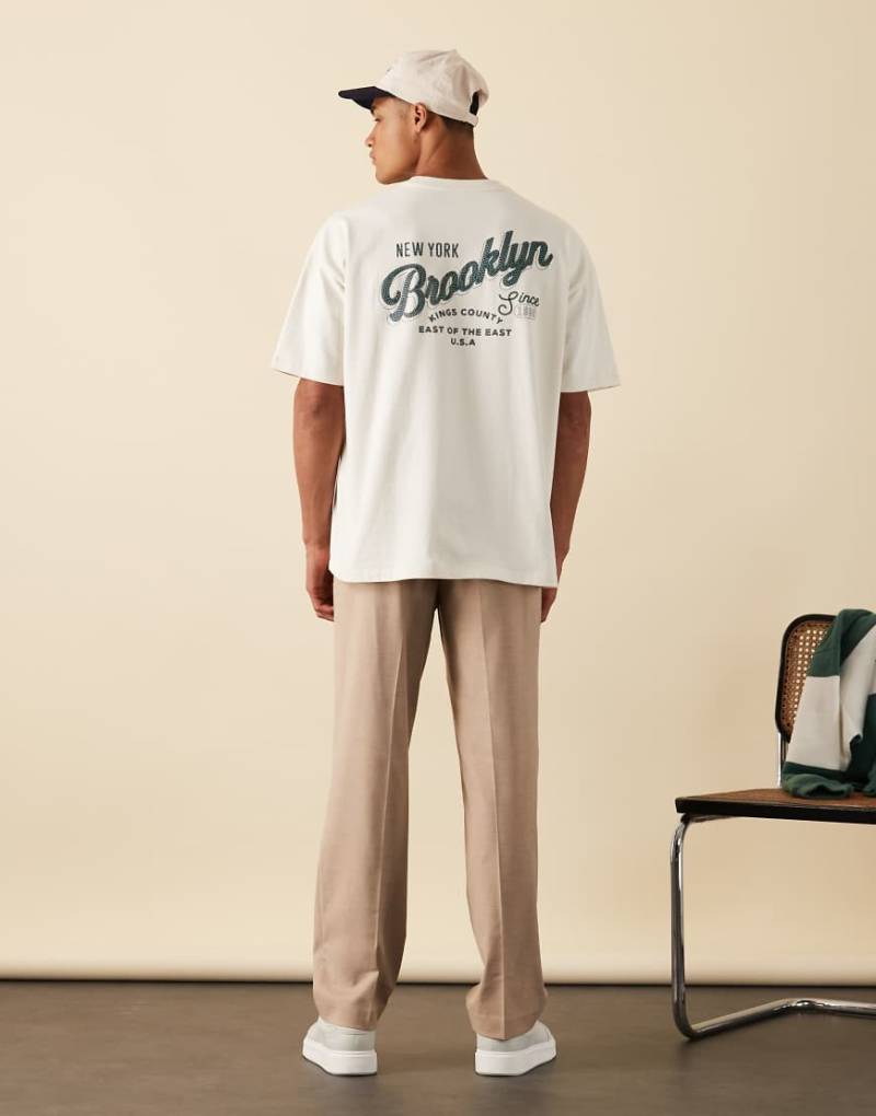 ASOS DESIGN - Kastiges Oversize-T-Shirt aus schwerem Stoff in Wollweiß mit City-Print von ASOS DESIGN