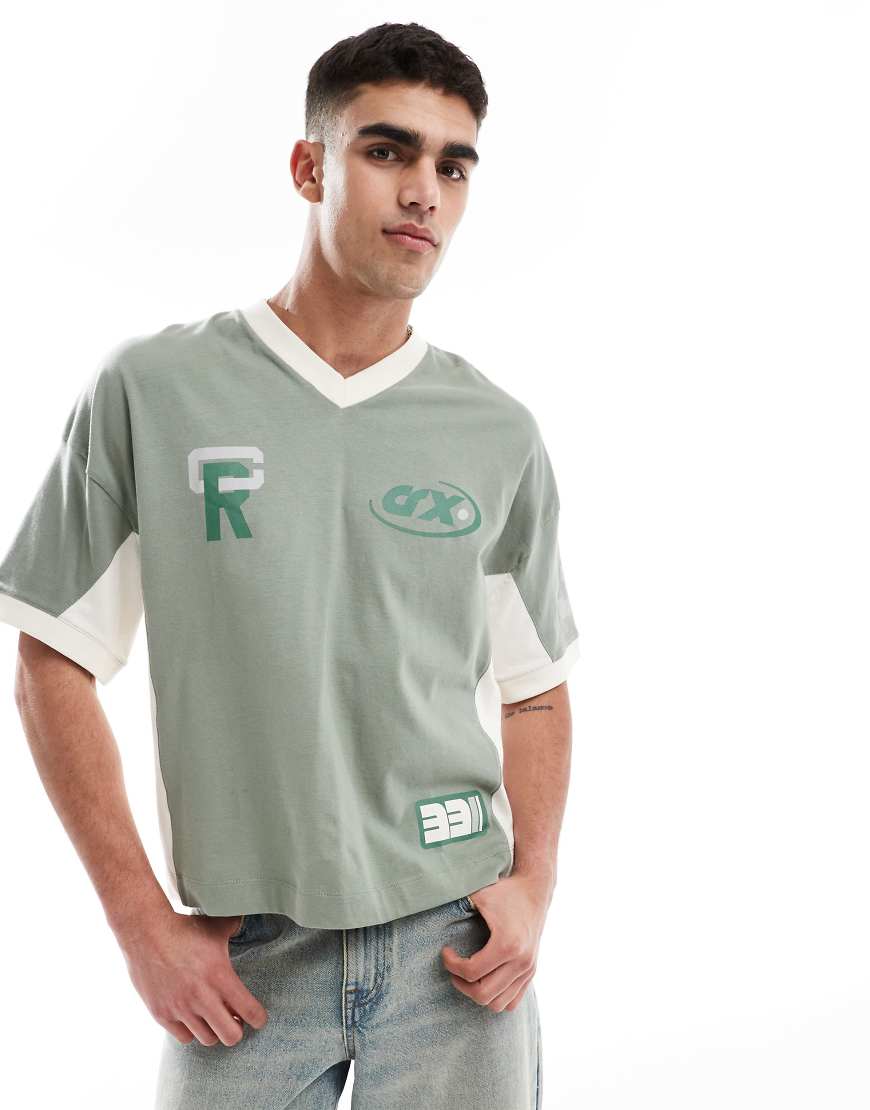 ASOS DESIGN - Kastiges Oversize-T-Shirt in Grün mit Sportgrafiken, überschnittenen Schultern und Schnitt- und Näheinsätzen von ASOS DESIGN