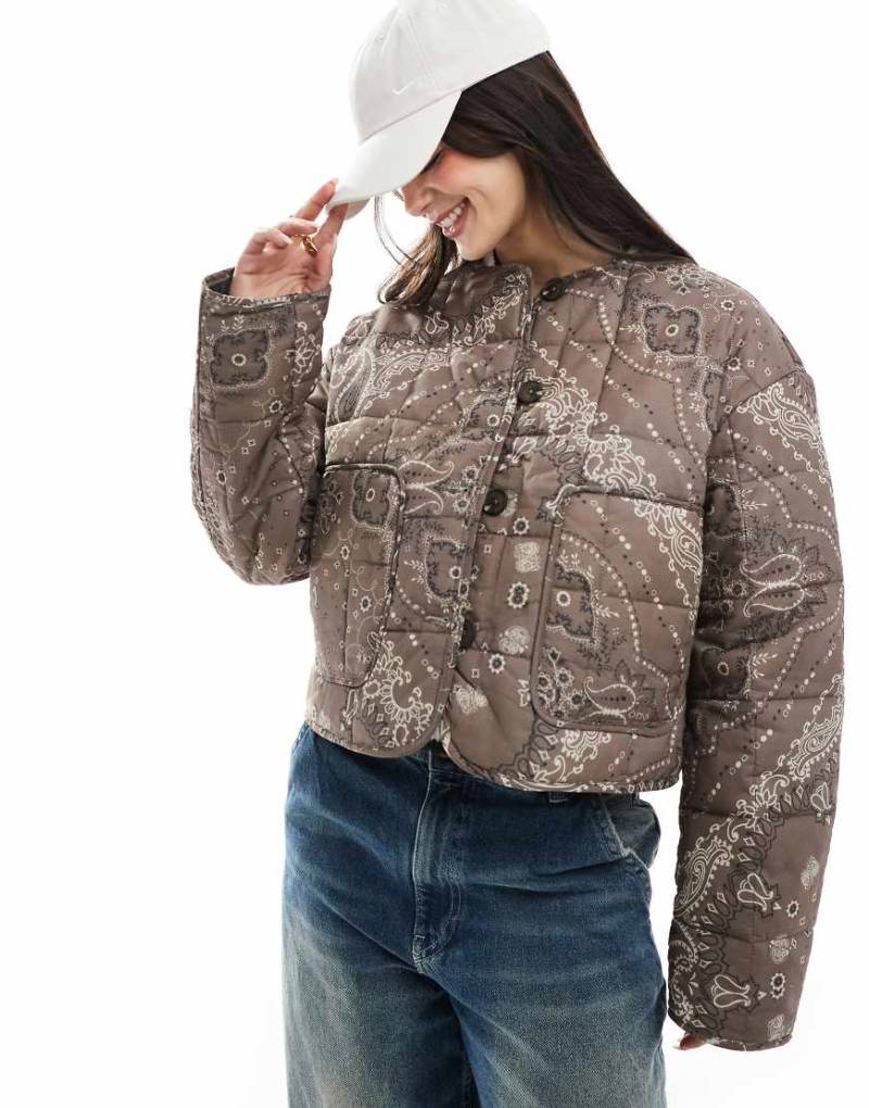 ASOS DESIGN - Kragenlose Cropped-Steppjacke in Schokobraun mit Bandanamuster-Bunt von ASOS DESIGN