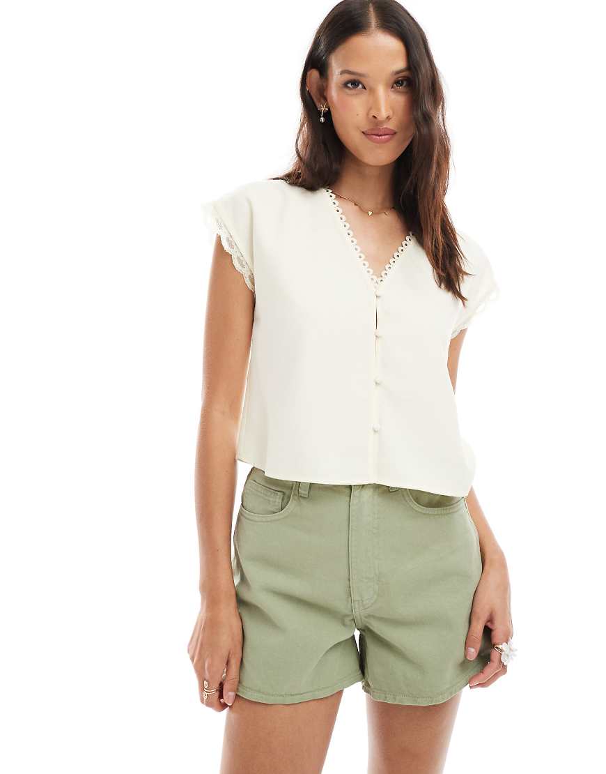 ASOS DESIGN - Kurzärmlige Bluse in Buttermilchgelb mit Spitzenbesatz ASOS DESIGN - Kurzärmlige Bluse in Buttermilchgelb mit Spitzenbesatz von ASOS DESIGN