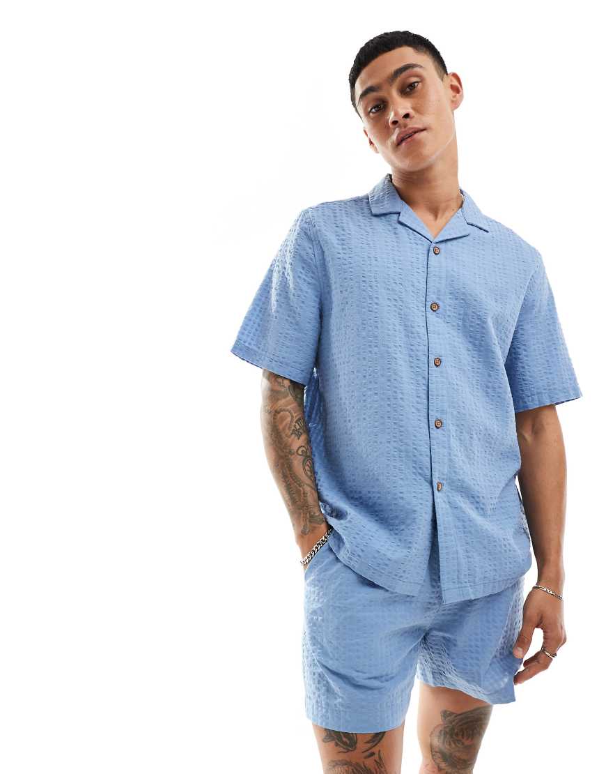 ASOS DESIGN - Kurzärmliges Oversize-Hemd im 90er-Stil in Staubblau mit Seersucker-Struktur, Kombiteil ASOS DESIGN - Kurzärmliges Oversize-Hemd im 90er-Stil in Staubblau mit Seersucker-Struktur, Kombiteil von ASOS DESIGN