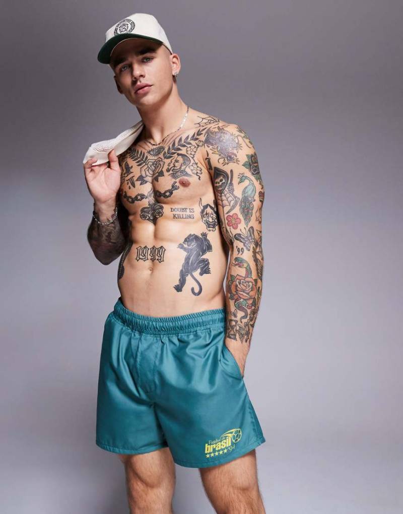 ASOS DESIGN - Kurze Badeshorts in Grün mit platziertem Print von ASOS DESIGN