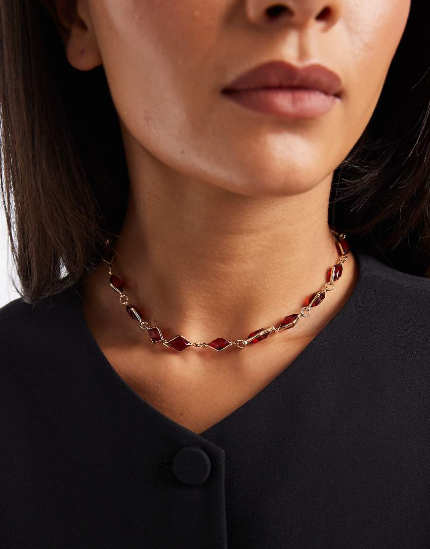 ASOS DESIGN - Kurze Halskette in Goldoptik mit eingefassten Schmucksteinen in Rot-Goldfarben von ASOS DESIGN