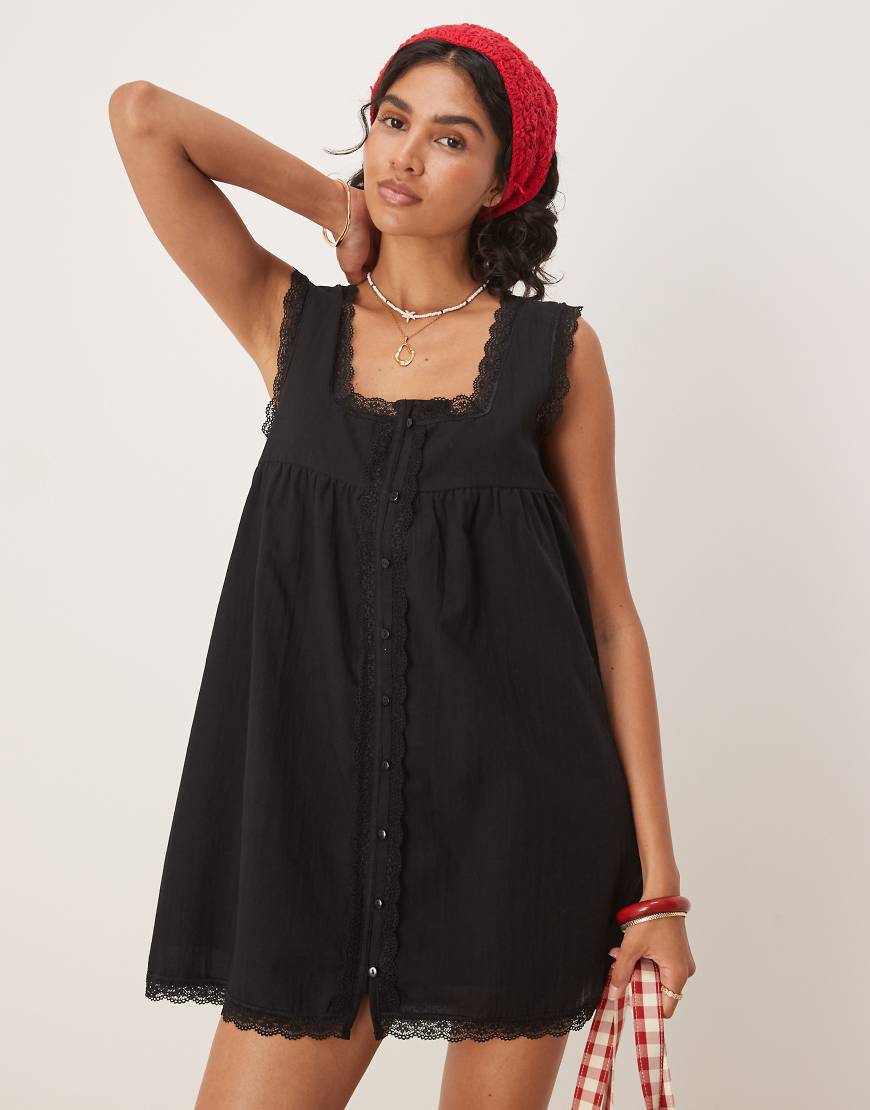 ASOS DESIGN - Kurzes Babydoll-Kleid aus Baumwolle in Schwarz mit Spitzenborte ASOS DESIGN - Kurzes Babydoll-Kleid aus Baumwolle in Schwarz mit Spitzenborte von ASOS DESIGN