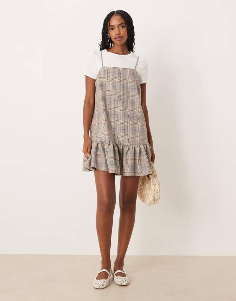 ASOS DESIGN - Kurzes Hybrid-Trägerkleid mit Karomuster in neutralen Tönen und Kontrast-T-Shirt von ASOS DESIGN