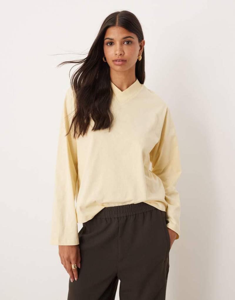 ASOS DESIGN - Langärmliges Shirt in Buttermilchgelb mit hoch angesetztem V-Ausschnitt von ASOS DESIGN