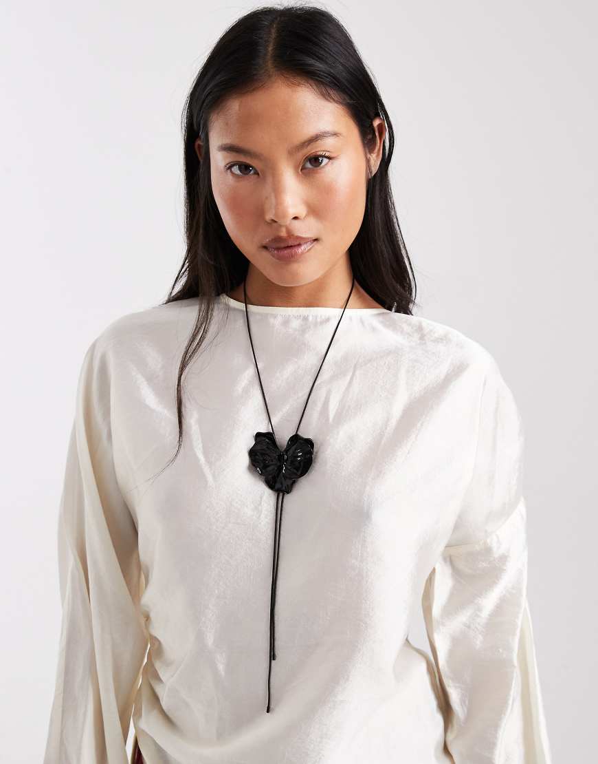 ASOS DESIGN - Lariat-Halskette in Schwarz mit Blumenverzierung von ASOS DESIGN