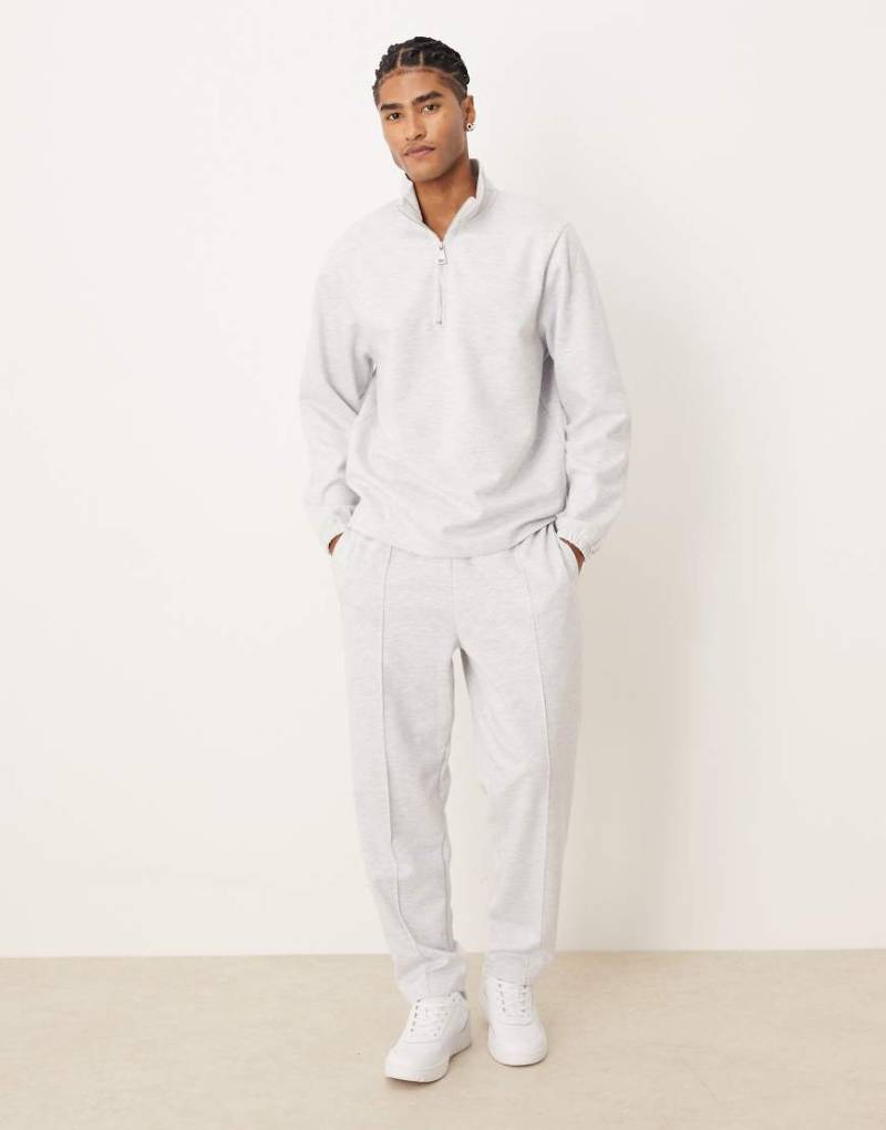 ASOS DESIGN - Schmal zulaufende, locker geschnittene Jogginghose aus neoprenartigem Material in Grau mit Biesen von ASOS DESIGN