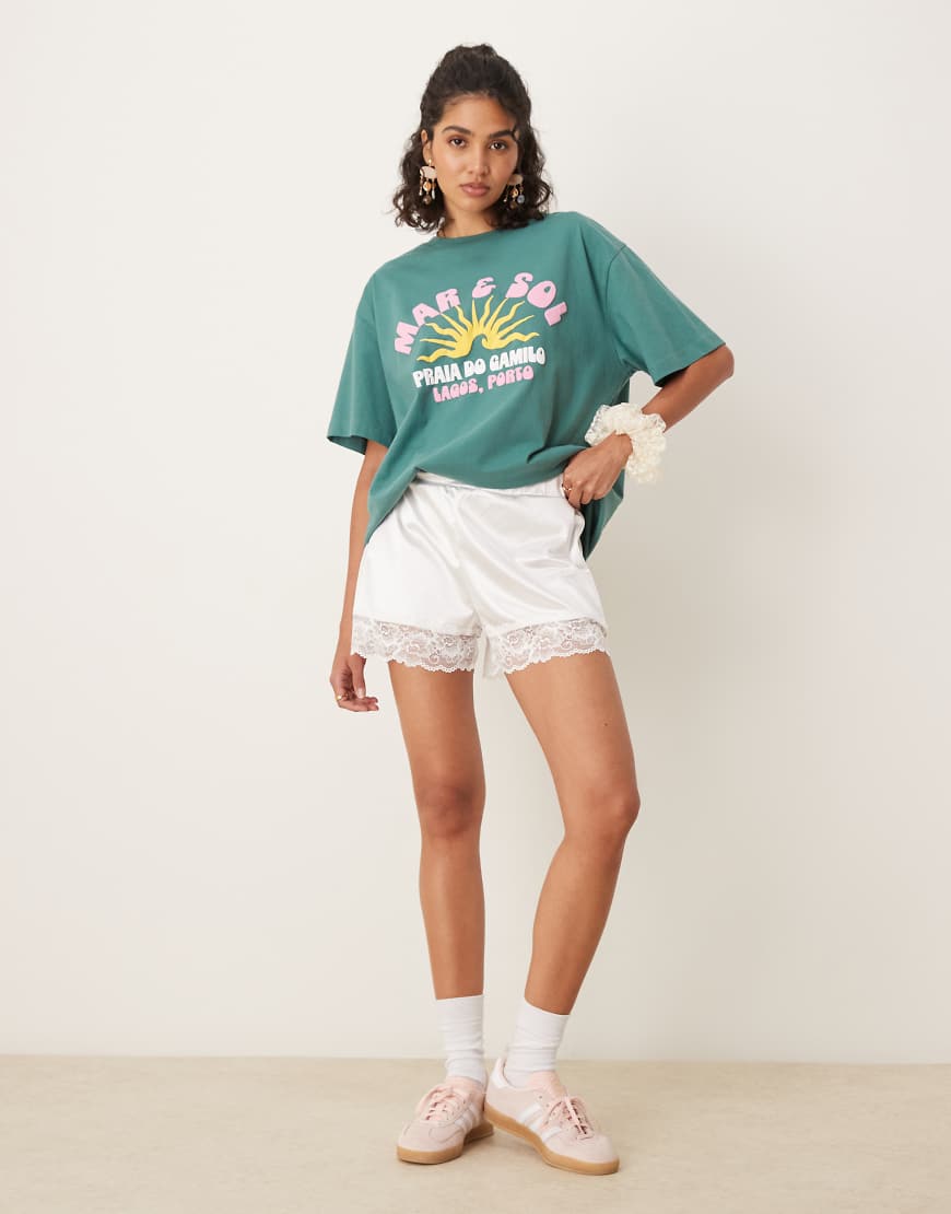 ASOS DESIGN - Locker geschnittene Shorts aus Stretch-Satin in Cremeweiß mit Spitzenborte-Goldfarben ASOS DESIGN - Locker geschnittene Shorts aus Stretch-Satin in Cremeweiß mit Spitzenborte-Goldfarben von ASOS DESIGN