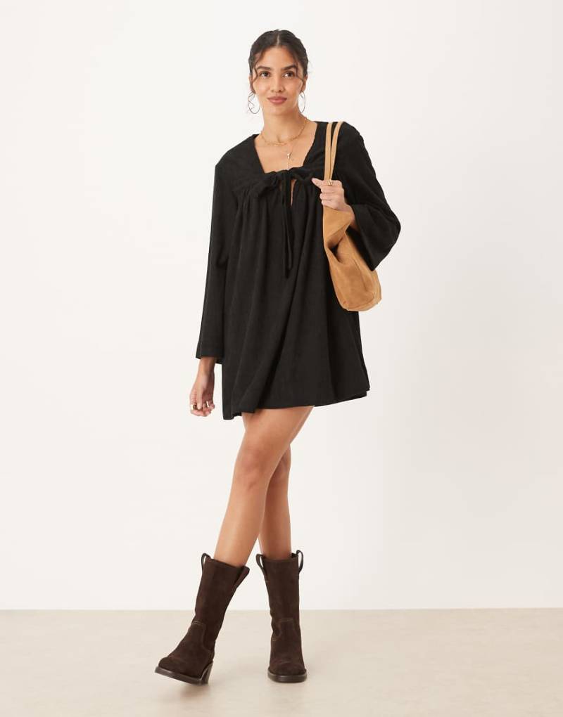 ASOS DESIGN - Mini-Hängerkleid aus Cord in Schwarz mit gebundener Vorderseite von ASOS DESIGN