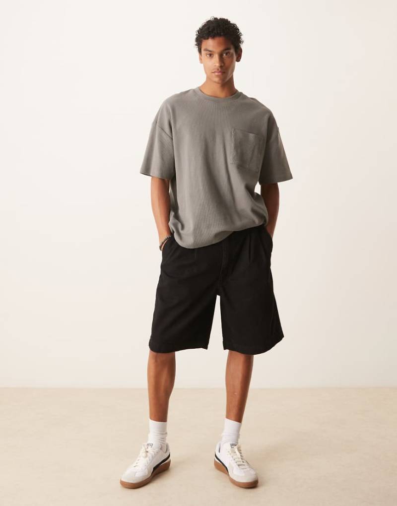 ASOS DESIGN - Mittellange, weite Denim-Shorts in schwarzer Waschung mit Bundfalten von ASOS DESIGN