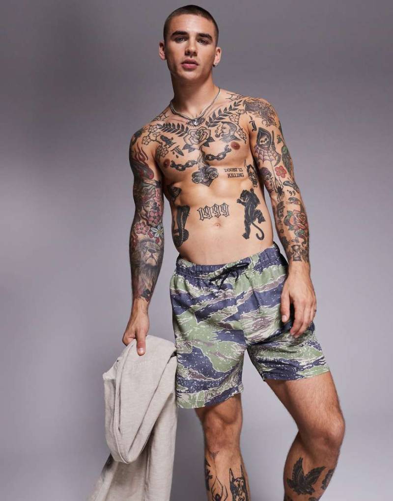 ASOS DESIGN - Mittellange Badeshorts in Grün mit Military-Muster von ASOS DESIGN