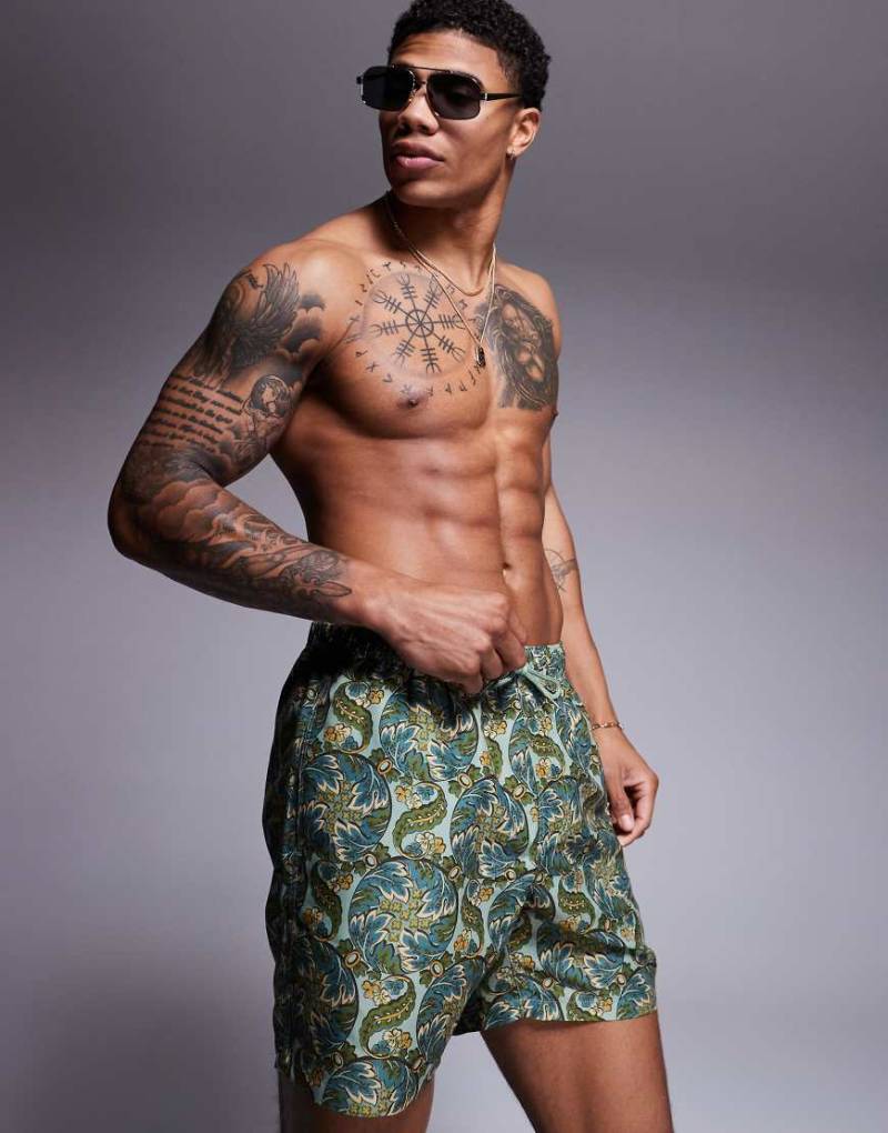 ASOS DESIGN - Mittellange Badeshorts in Salbeigrün mit Paisley-Print von ASOS DESIGN