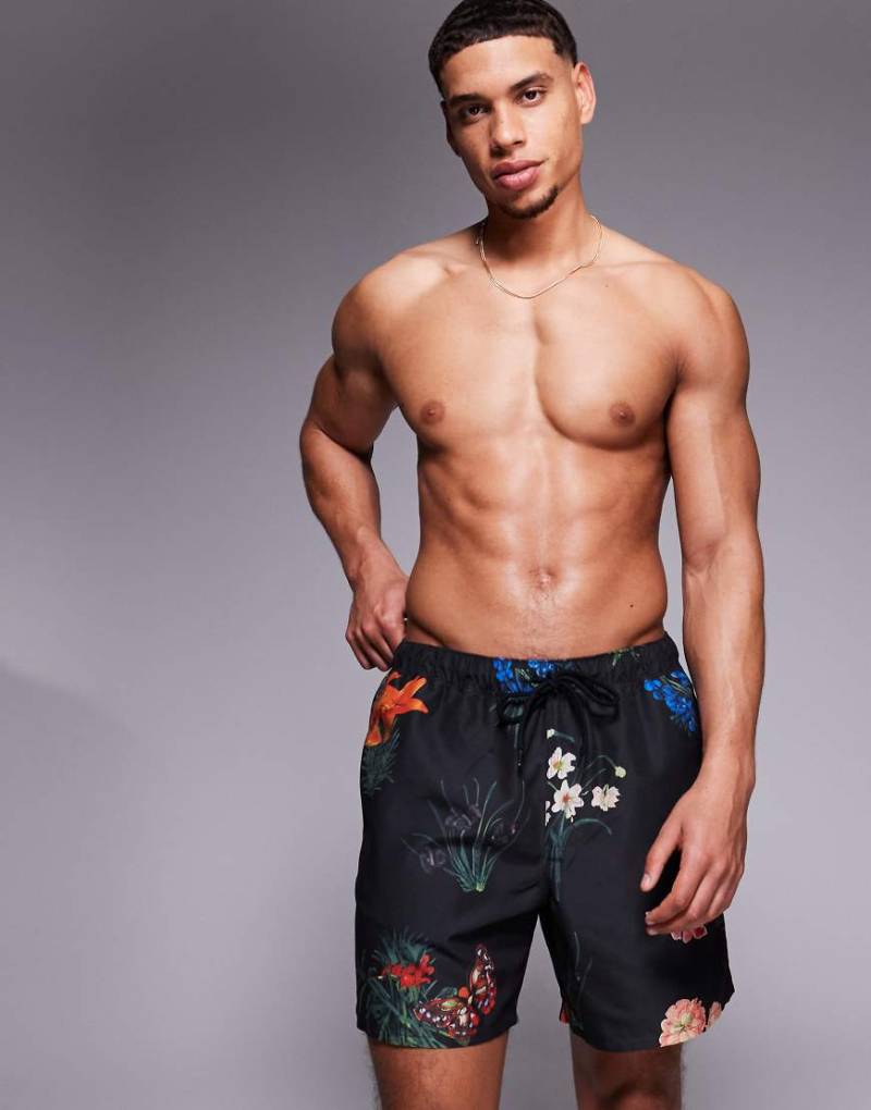 ASOS DESIGN - Mittellange Badeshorts in Schwarz mit Blumenprint von ASOS DESIGN