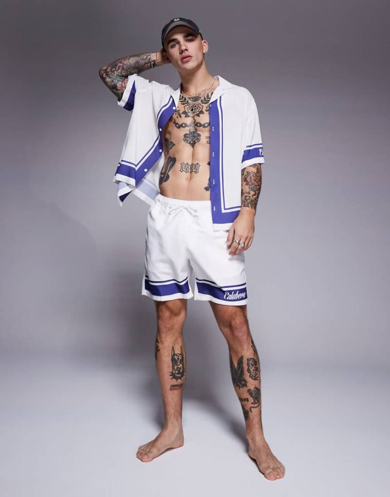 ASOS DESIGN - Mittellange Badeshorts in Weiß mit Textgrafik, Kombiteil von ASOS DESIGN