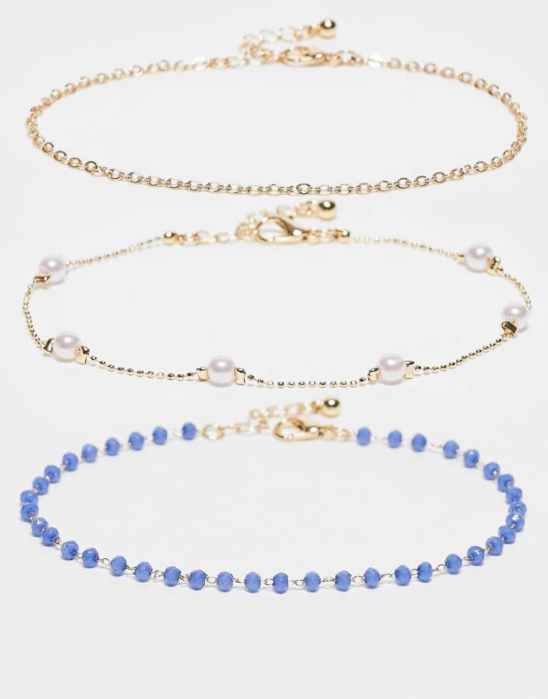 ASOS DESIGN - Multipack Fußkettchen in Gold-Optik mit verschiedenen Designs mit blauen Schmucksteinen und Zierperlen-Goldfarben von ASOS DESIGN