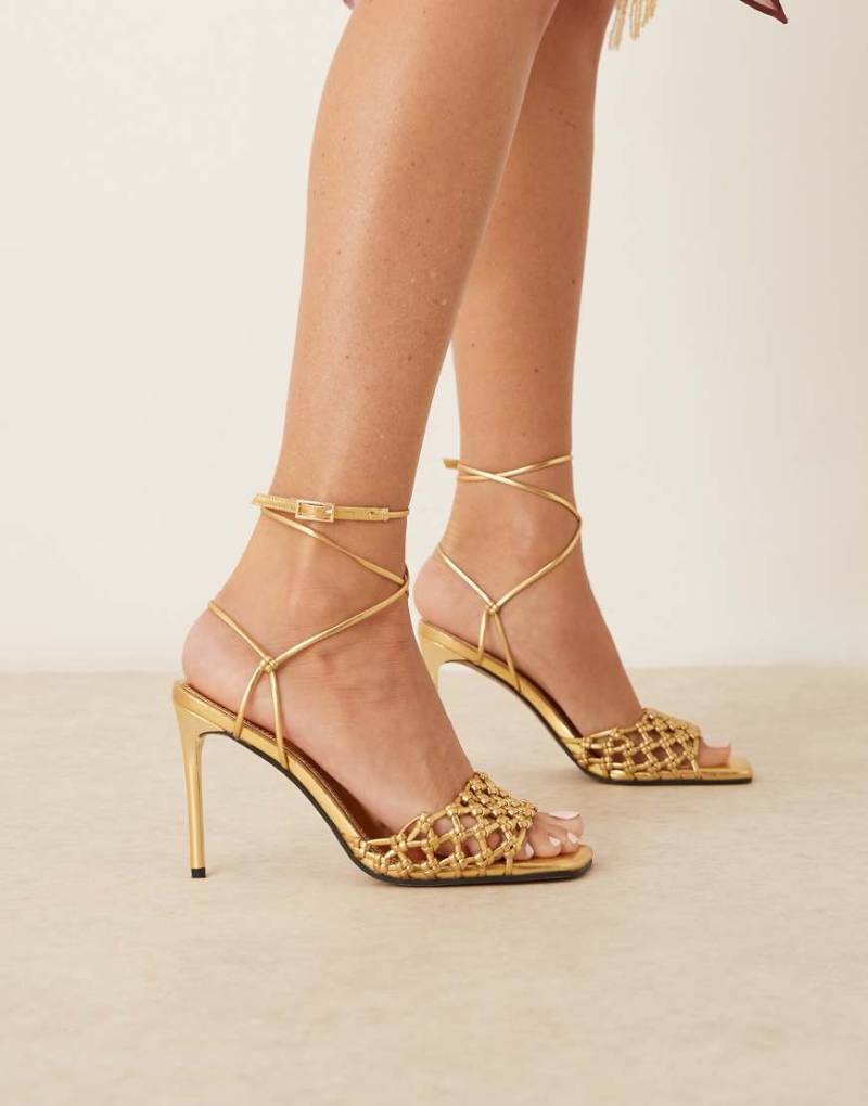 ASOS DESIGN - Nadine - Geknotete Sandaletten in Gold mit hohem Absatz-Goldfarben von ASOS DESIGN