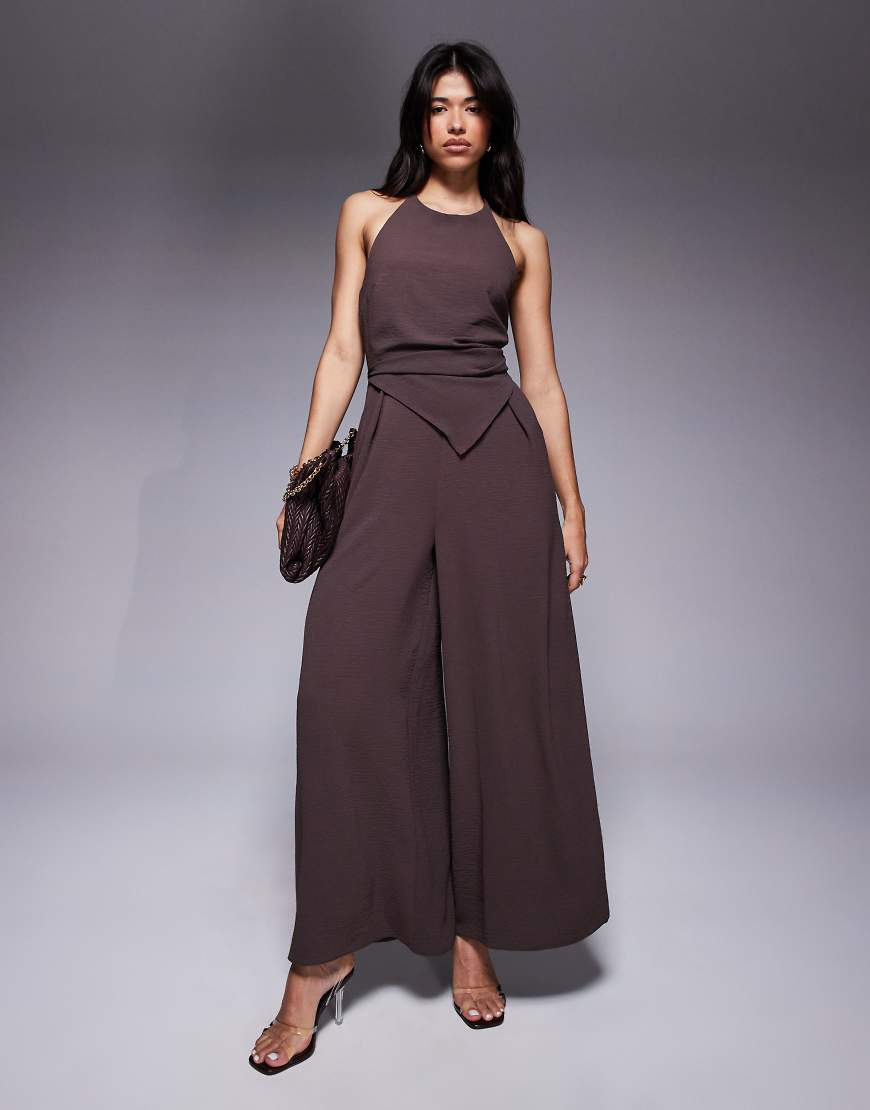 ASOS DESIGN - Neckholder-Jumpsuit in Schokobraun mit asymmetrischem Overlay ASOS DESIGN - Neckholder-Jumpsuit in Schokobraun mit asymmetrischem Overlay von ASOS DESIGN