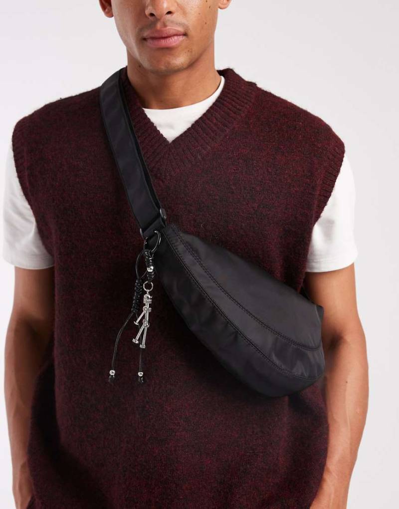 ASOS DESIGN - Nylon-Umhängetasche in Schwarz mit Anhänger von ASOS DESIGN