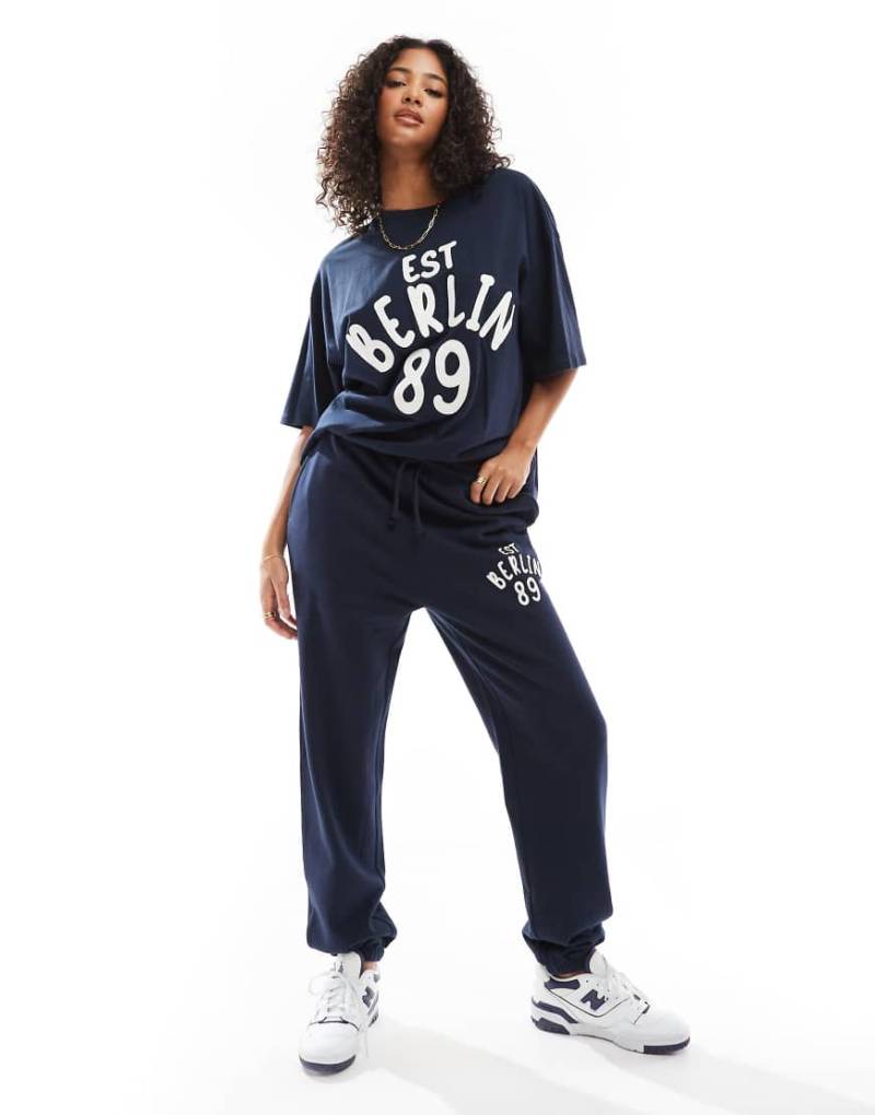 ASOS DESIGN - Oversize-Jogginghose in Marineblau mit Bündchen und „Berlin"-Applikationsprint, Kombiteil von ASOS DESIGN