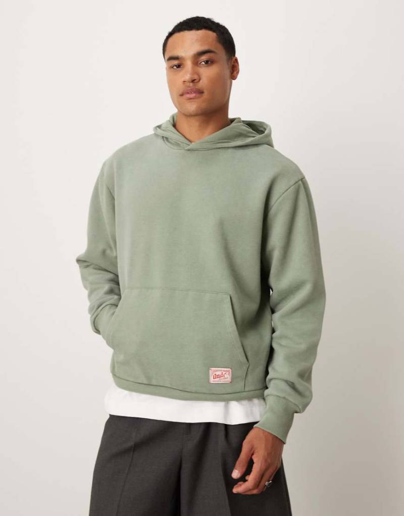 ASOS DESIGN - Oversize-Kapuzenpullover in verwaschenem Grün mit gewebtem Etikett-Detail von ASOS DESIGN