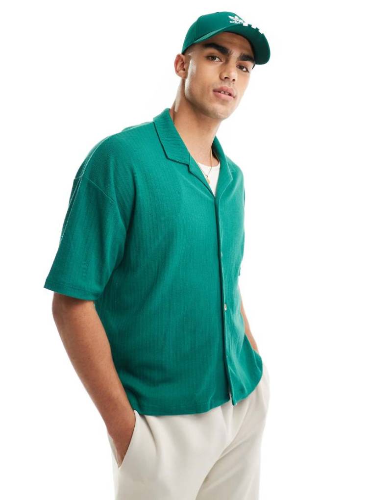 ASOS DESIGN - Oversize-Polohemd in Grün mit durchgehender Knopfleiste von ASOS DESIGN
