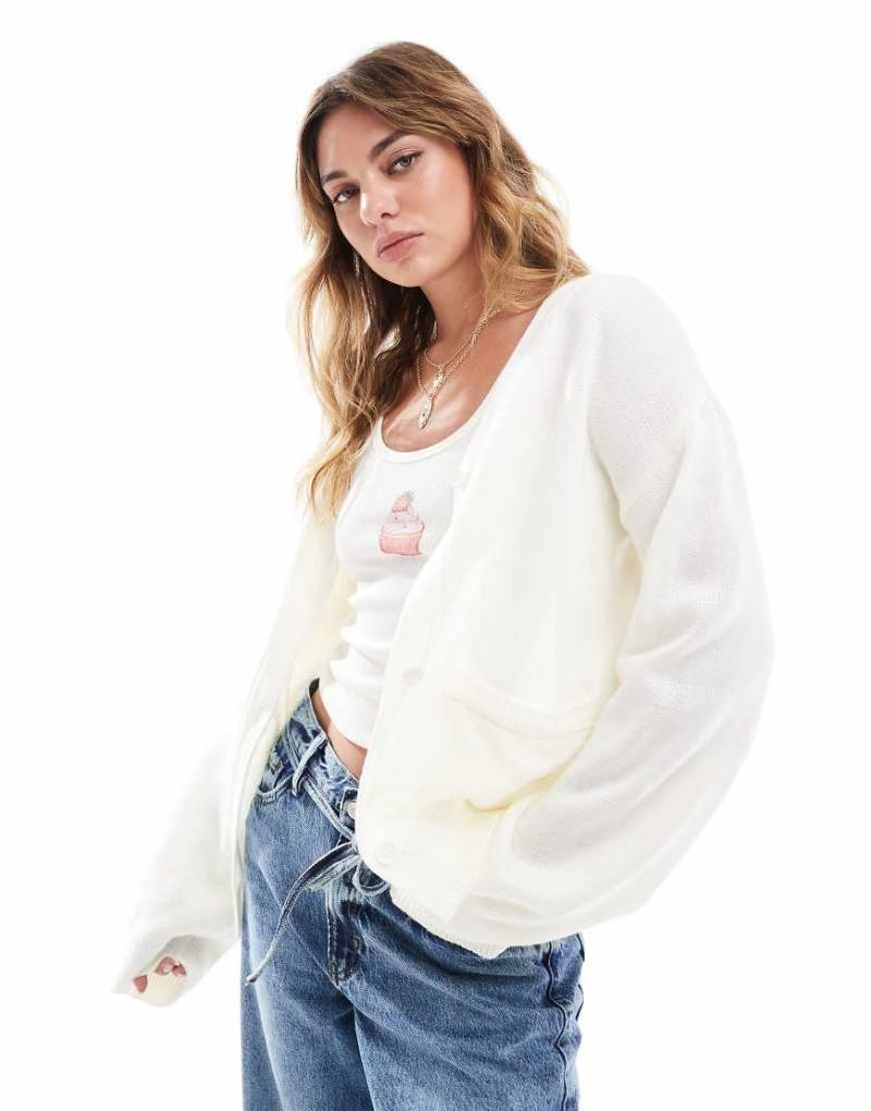 ASOS DESIGN - Oversize-Strickjacke in Cremeweiß mit Taschen von ASOS DESIGN