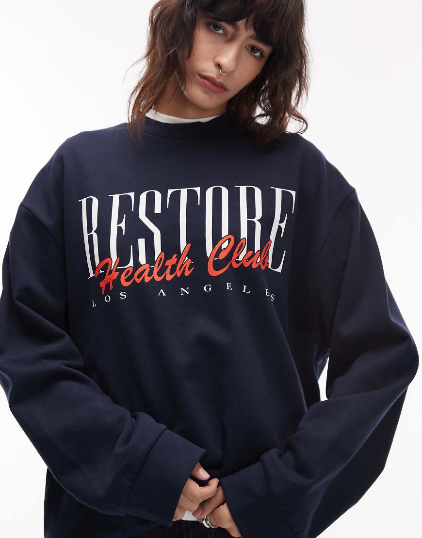 ASOS DESIGN - Oversize-Sweatshirt in Marineblau mit „Restore Health"-Grafikprint von ASOS DESIGN